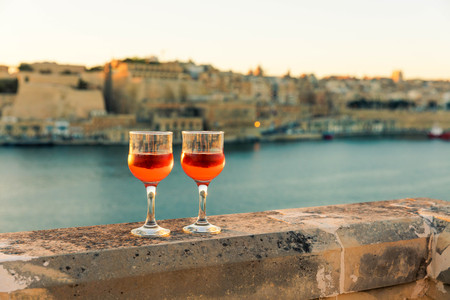 Cheers from Malta, sunset over Valletta with wine glassesの写真素材
