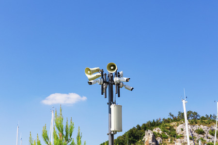 Multiple security cameras and loudspeakers on poleの写真素材