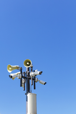 Multiple security cameras and loudspeakers on pole