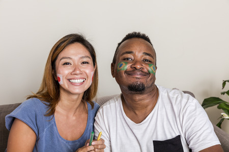 Japanese girl and Brazilian guy with facepainted flags before game