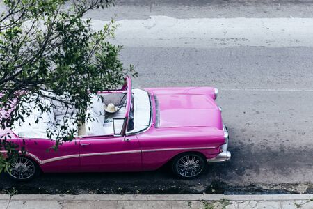 Vintage pink car parked on the street in downtown Havana, Cubaの写真素材