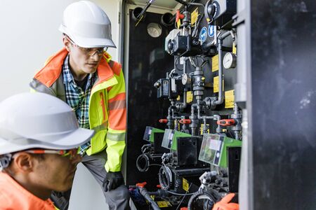 Engineers checking  measuring devices in industrial environment
