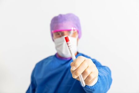 Doctor in a protective suit holding a nasal swab used to test for possible coronavirus infectionの写真素材