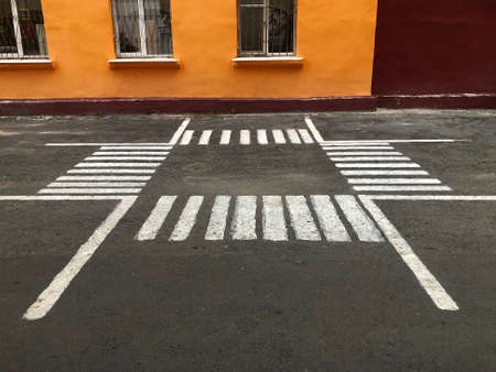 four pedestrian crossings are painted on the asphalt in the form of a square next to the school buildingの写真素材