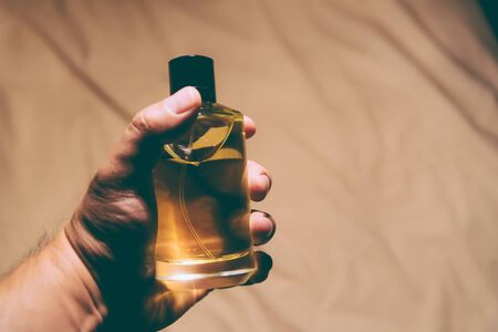Man holding a bottle of perfume -  backlightの写真素材