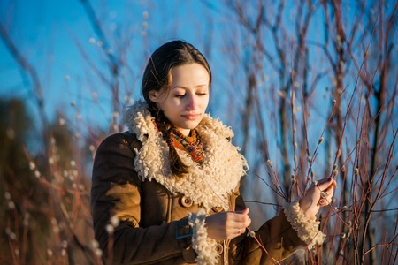 young beautiful woman in national russian suite at snowy winter