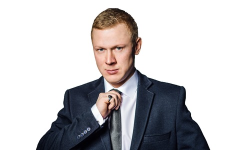 Fashionable serious  businessman preparing his tie isolated over white