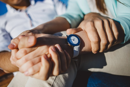 Couple  holding hands with white watches in sunny day.の写真素材