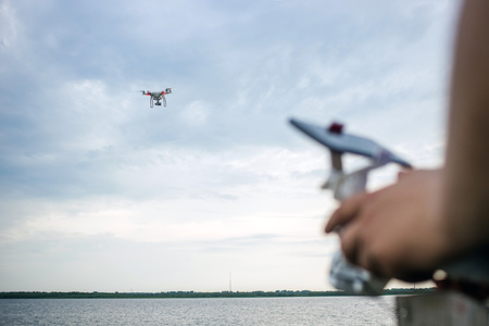A man flying a drone over a water surface.