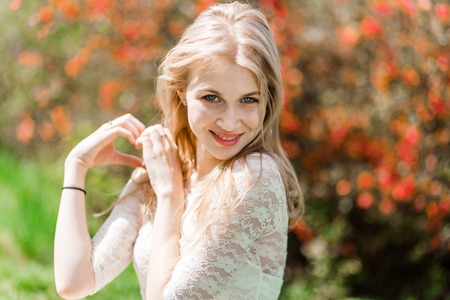 Beautiful blonde showing heart shape. Bloomig garden. Good weatherの写真素材