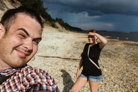 Two hikers taking selfie on forest edge at sunny day.の写真素材