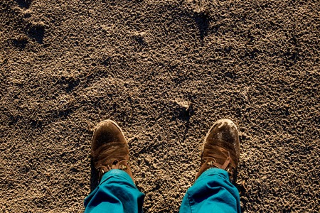Male shoes on textured sand contrast blue trousers.の写真素材