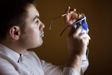 the man wipes with a rag of a lens of computer glasses.の写真素材