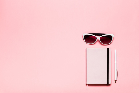 Pink diary, white pen, glasses and cactus on pink background. flat lay, top view. Feminine workspaceの写真素材
