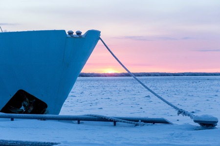 frozen ship cable under snow, bollard at the pier in winter.の写真素材