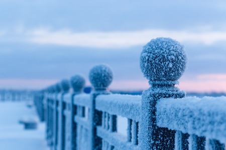 Winter landscape. Frosty morning, an iron chain on the embankment covered with a thick layer of frost, clouds of vapor above the freezing river.の写真素材