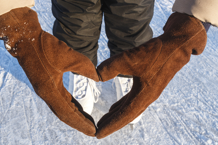 Abstract Heart of Gloves and Ice Skates in Background Bokeh. Concept Love Outoor Winter Skating.の写真素材