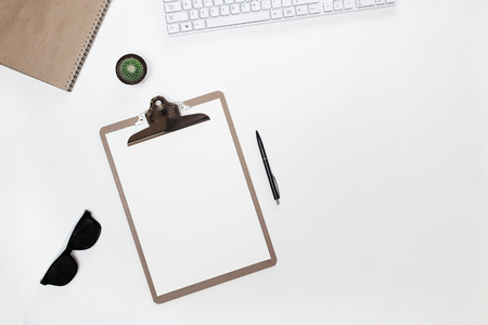 White home office desk table with white keyboard, folder tablet, sunglasses and cactus and mint diary. Top view with copy space, flat lay, scandinavian design.の写真素材