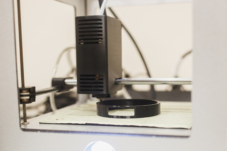 Close up of a 3D printer being in work. Cylindric detail printing