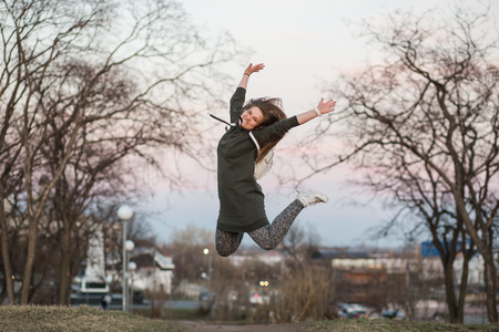 Happiness and freedom concept. Outdoor portrait of beautiful stylish young European female model...