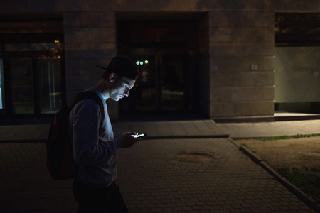The man phone on the street. Evening night time. Street lights. Telephoto lens shotの写真素材