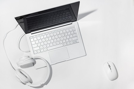 Laptop, White headphones and wireless mouse on a white background. Flat lay with copy space.の写真素材