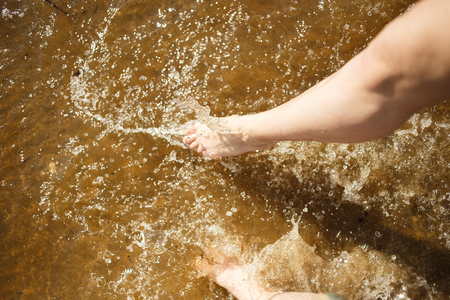 Couple legs splashing the sea water. Summer joyの写真素材