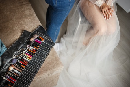 Concept of wedding makeup. Professional make up artist applying make up for bride on the wedding day with focus on the brushes. Copy space.の写真素材