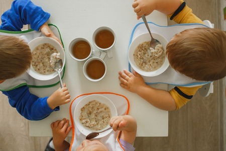 Kids eating healthy breakfast in kindergartenの写真素材