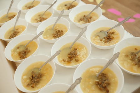 Lunch set (vegetable soup, crackers, plates, spoon) were prepared for children on the long table in the kindergartenの写真素材