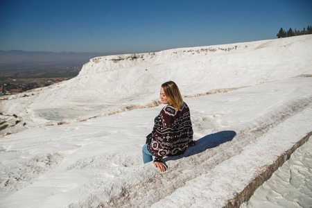 Beautiful girl wearing on dark ethnic sweater relaxing at Pamukkale.の写真素材