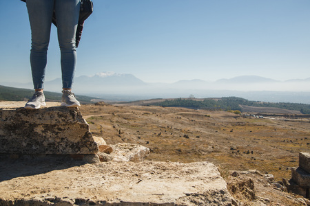 Female tourist feet in ancient ruins. Panoramic view in mountains. Copy space. Tourism conceptの写真素材