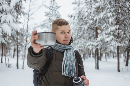 Stylish  with a  of hot tea in a snowy conifer forestの写真素材