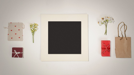 Composition with black photo frame, red gift boxes, craft bag, canvas bag with red heart shapes and...