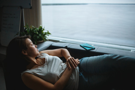 Young business woman resting on the office couch.の写真素材