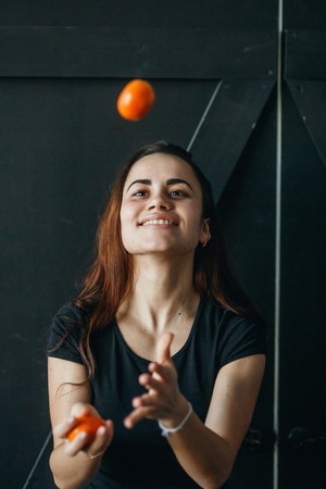Young girl having fun with sweet tangerines