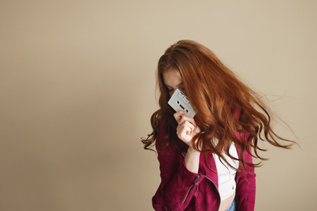 Young hipster woman with white retro audio cassette. Party 90s concept