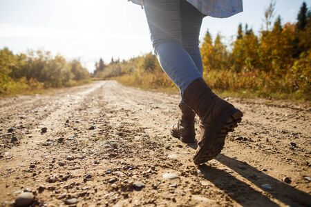 Hiking woman with leather boots on autumn forest trailの写真素材