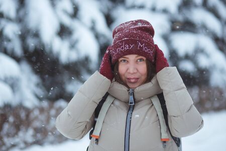 People, season and holidays concept - portrait of happy smiling young woman outdoors in winter park....