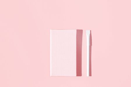 Feminine pink notebook on a pink background, flat lay with copy spaceの写真素材