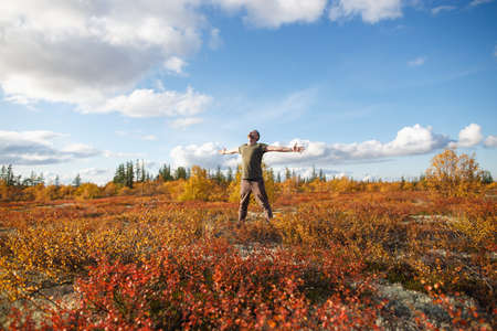 Handsome man hiker enjoying good weather in autumn tundra