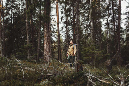 A man makes his way through thickets in the deep taiga forestの写真素材
