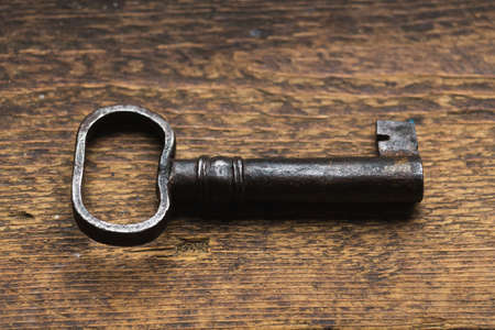 Old key on a dark wooden backgroundの写真素材