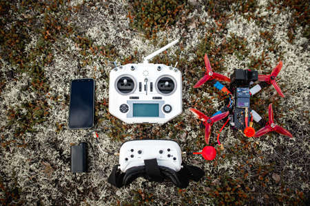 Set of homemade quadcopter with battery, remote control, camera for video, flat lay outdoorsの写真素材