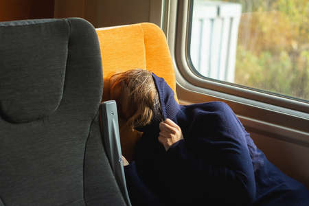 Young woman traveler sleeping inside of suburban train.の写真素材