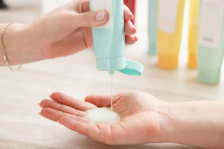 Womens hands applying cleansing lotion with to cleanse the skinhygiene tubes on white background,...