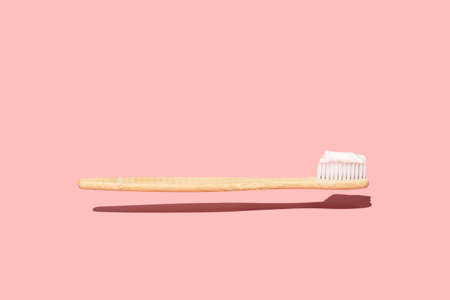 Levitating Wood Toothbrush with Toothpaste On Pink Backgroundの写真素材