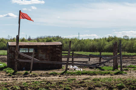 Guards booth with red flag and fields of beds in springの写真素材