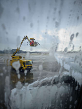 anti-icing processing of aircraft wing in airport in winter eveningの写真素材