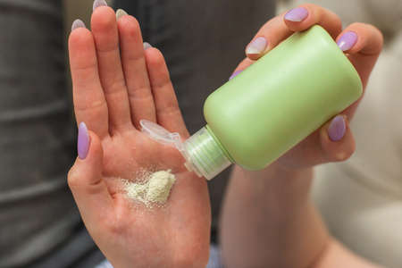 Womans Hand Using Talcum Powder for Her Skinの写真素材